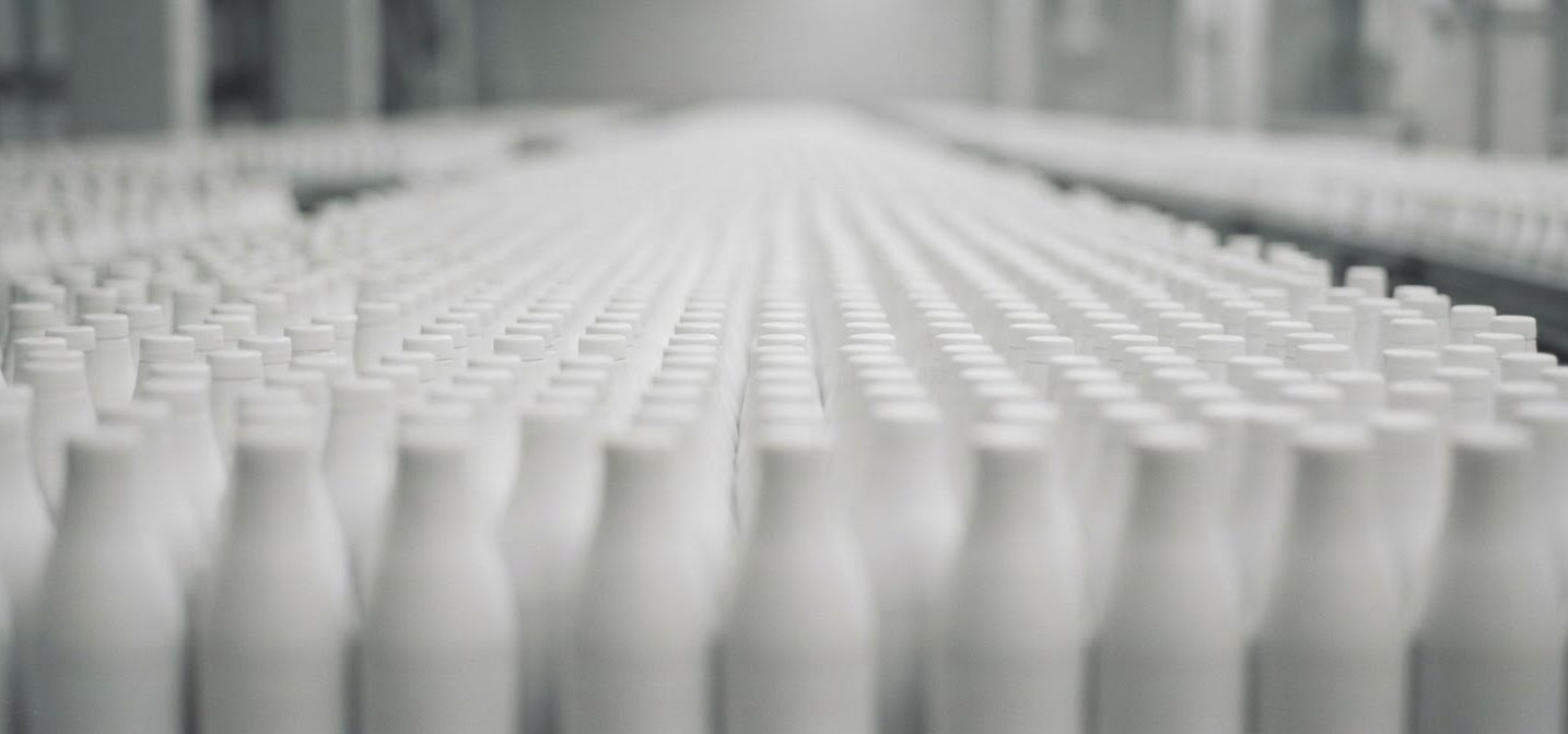 Rows of white cosmetic bottles in soft focus