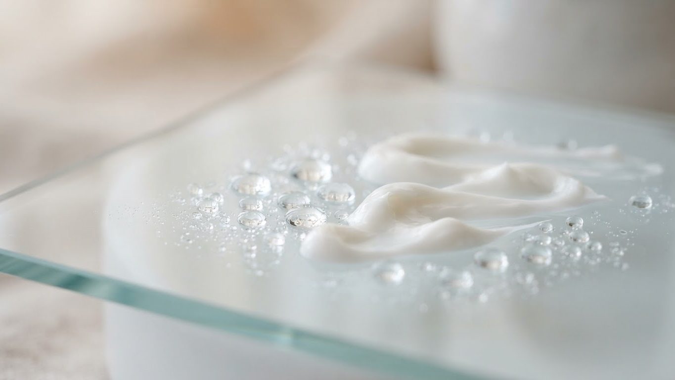 Water droplets and white cream texture on glass